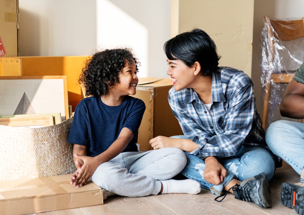 Mother and son packing boxes together
